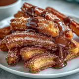 Crispy, cinnamon-sugar churro bites paired with warm, silky chocolate sauce—perfect for sharing on Cinco de Mayo.  