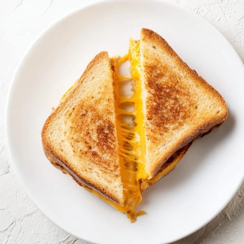 Close-up of a perfectly browned grilled cheese; a simple, comforting lunch or dinner.