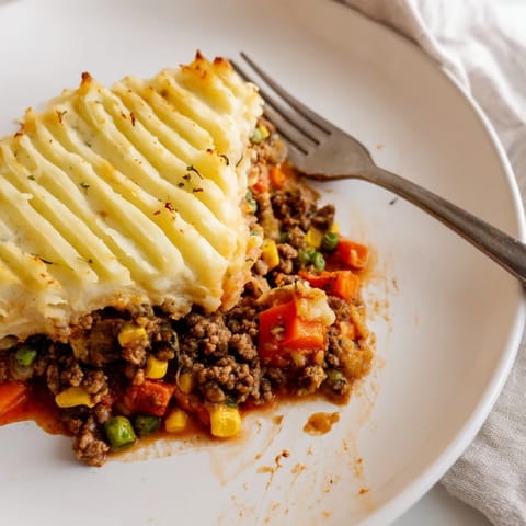 A steaming, hearty Shepherd's Pie overflowing with savory meat and fluffy mashed potato top.