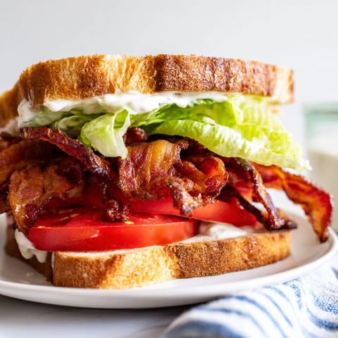 A perfectly stacked BLT Sandwich showcases layers of toasted bread, bacon, and creamy mayonnaise.