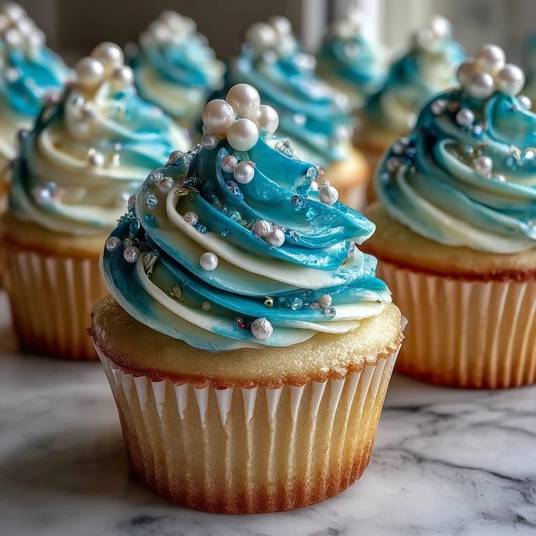 Elegant Cancer birthday cupcakes featuring creamy frosting and shimmering edible pearl accents.